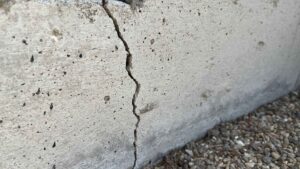 A close-up view of a vertical crack in a concrete foundation