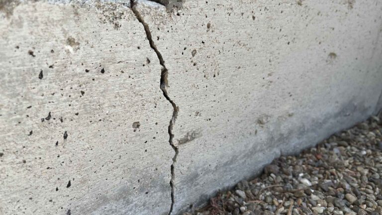 A close-up view of a vertical crack in a concrete foundation