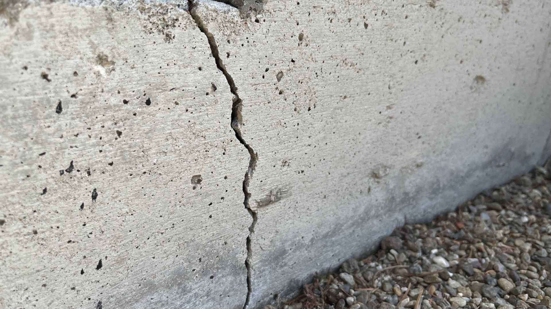 A close-up view of a vertical crack in a concrete foundation